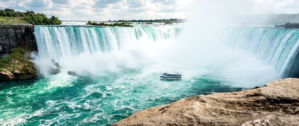 A boat steers near the base of Niagara Falls, seen from the Canadian side.