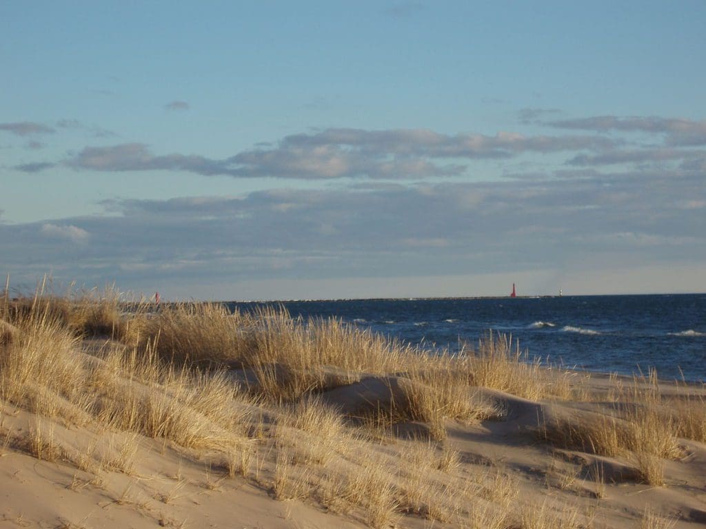 South-west view from the shoreline of Muskegon State Park. The Muskegon Channel leading into Muskegon Lake is visible in the distance at one of the best places in Michigan to visit with kids.