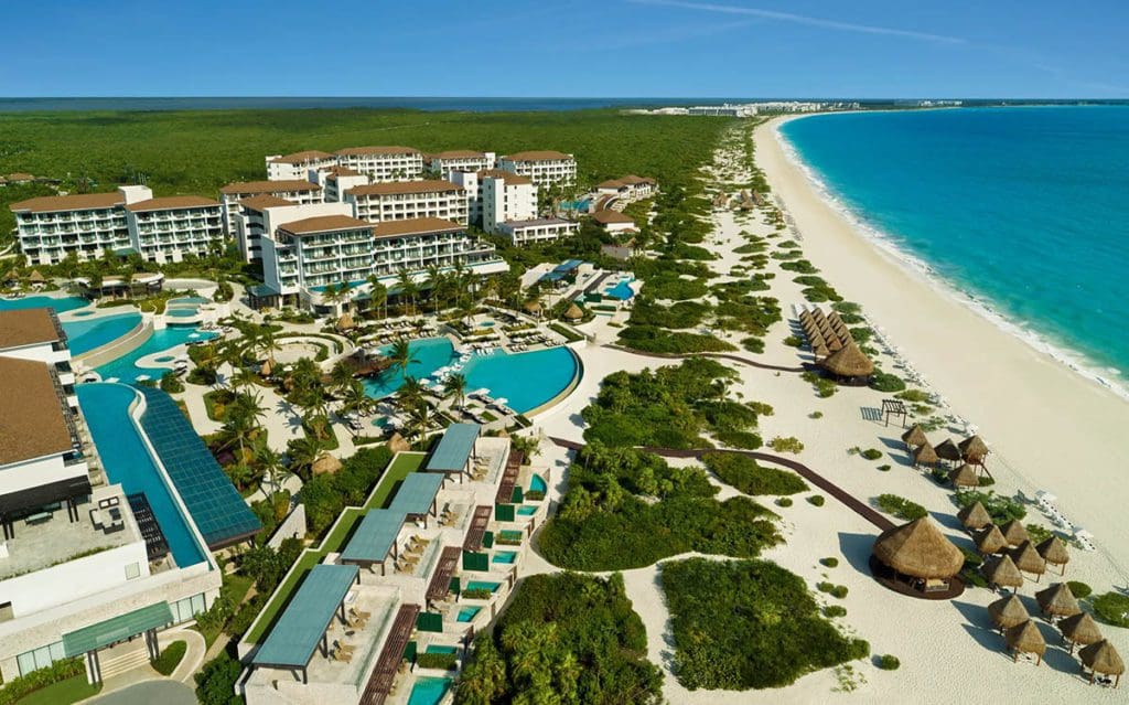 An aerial view of Dreams Playa Mujeres Golf & Spa Resort, with a long stretch of beach on one side.