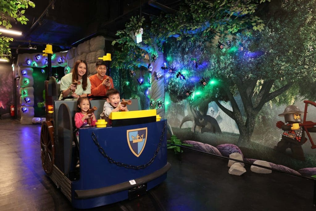 A family of four goes through a lego-themed ride at LEGOLAND Discovery Center Michigan, one of the best places in Michigan to visit with kids.