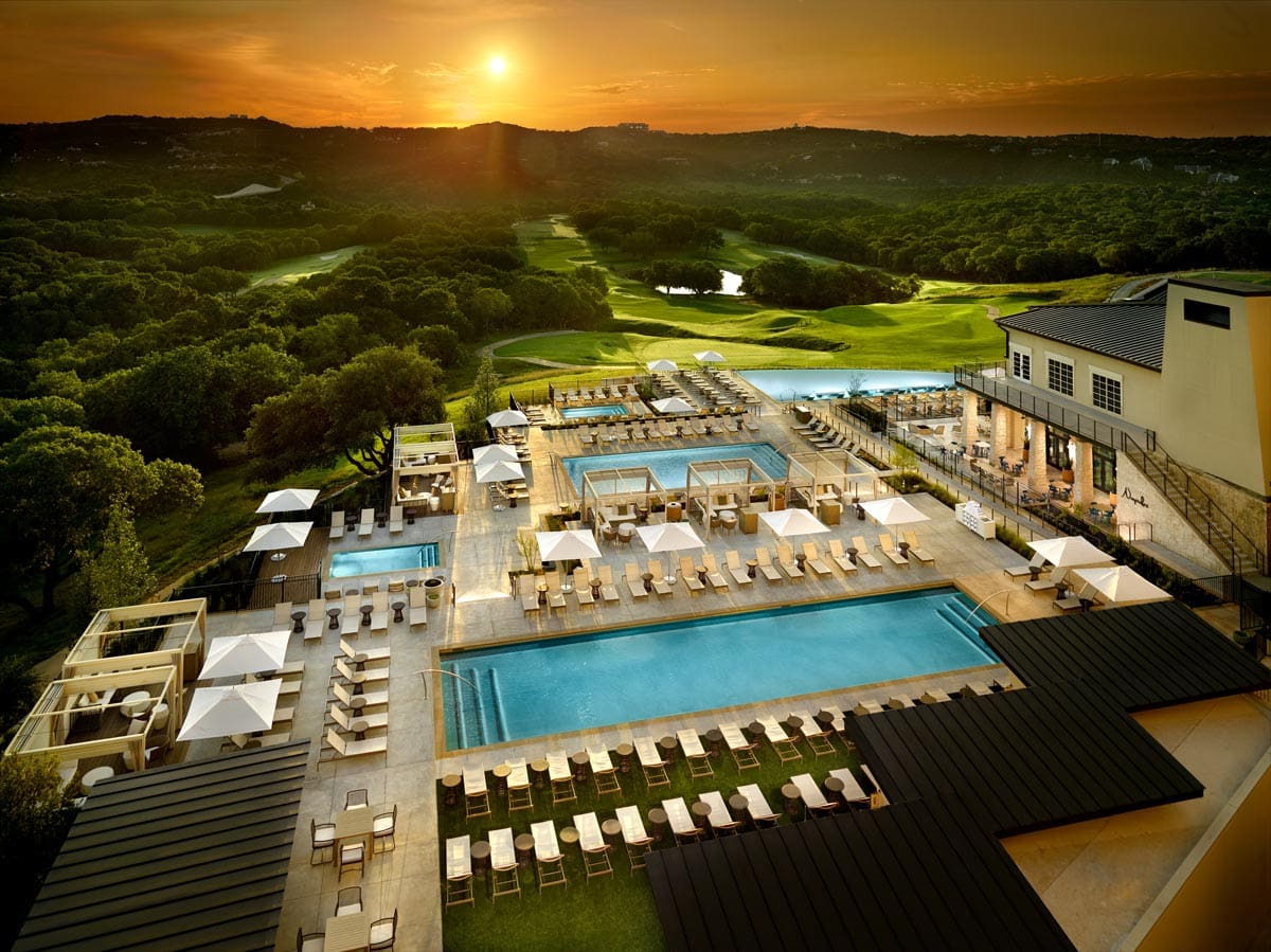 An aerial view of the outdoor pool and surrounding pool deck at sunset at Omni Barton Creek Resort & Spa.