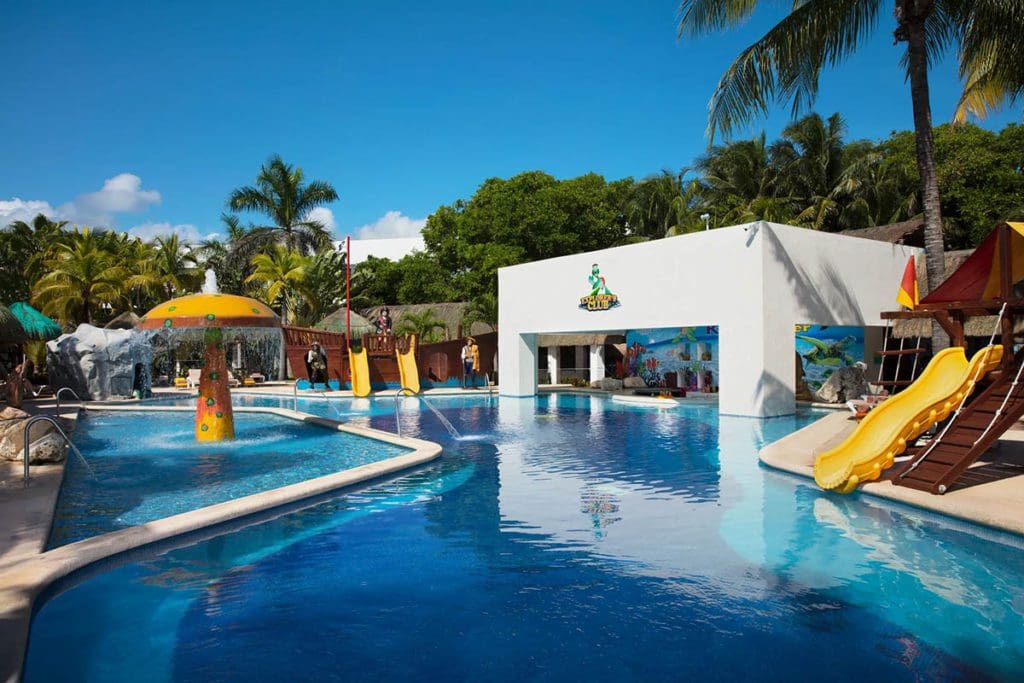 The small water park at Sunscape Akumal Beach Resort & Spa, featuring kid's slides and a splash zone area.