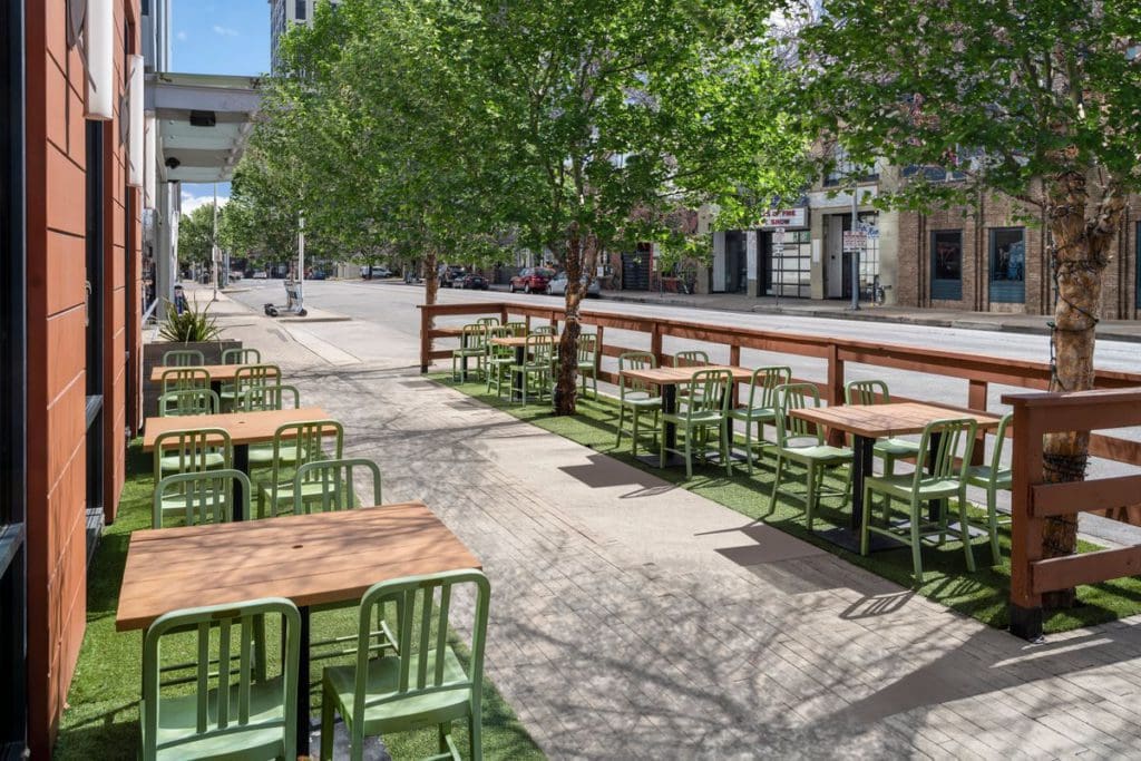 The outdoor patio along a sidewalk at The Westin Austin Downtown, featuring lime green chairs.