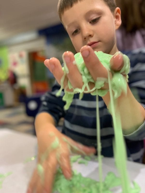 A young boy plays with green slime at The Upper Peninsula Children's Museum.