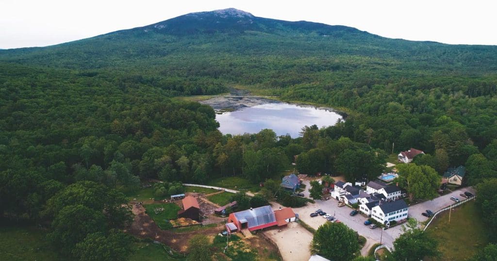 An aerial view of the grounds of The Inn at East Hill Farm, nestled in the mountains, at one of the best all-inclusive hotels in the United States for families.