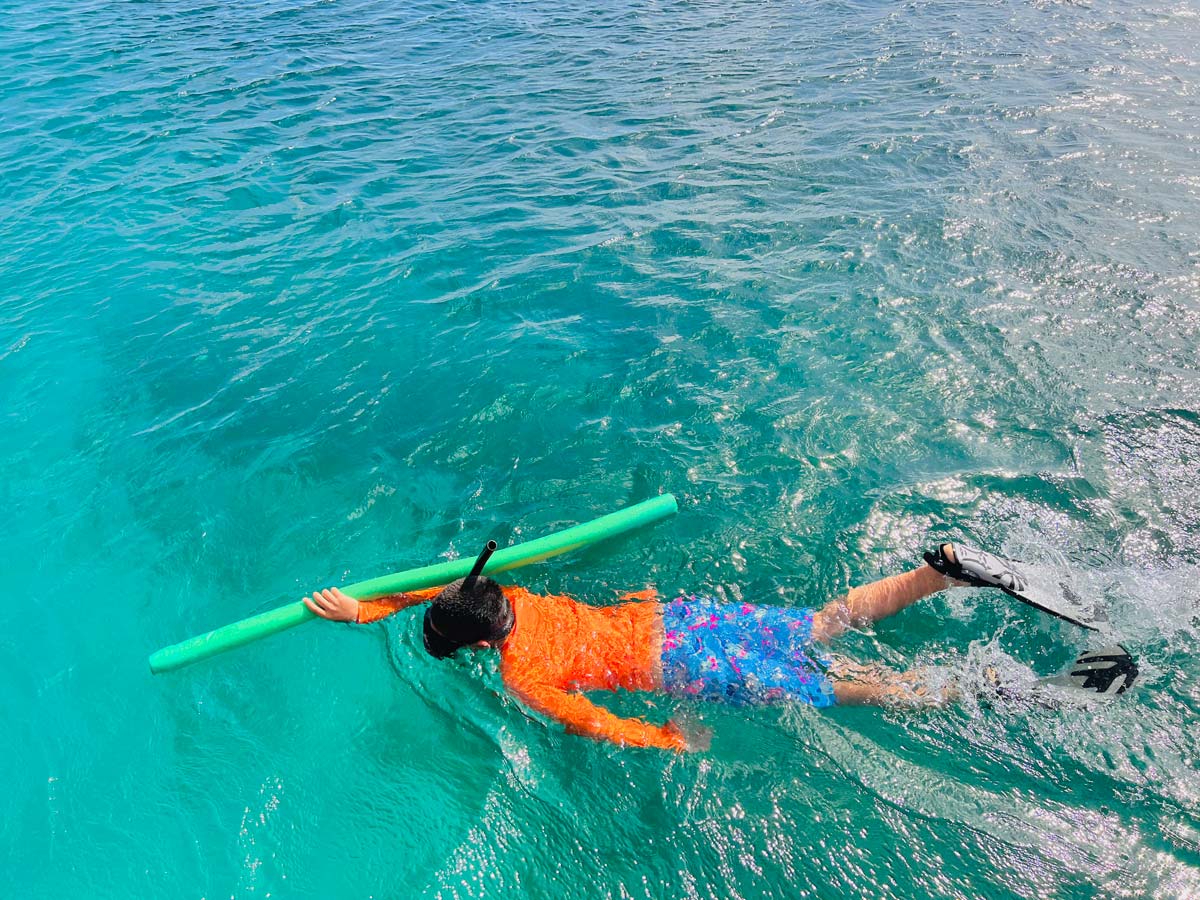 Aerial view of a young boy snorkeling in the ocean near Anguilla.