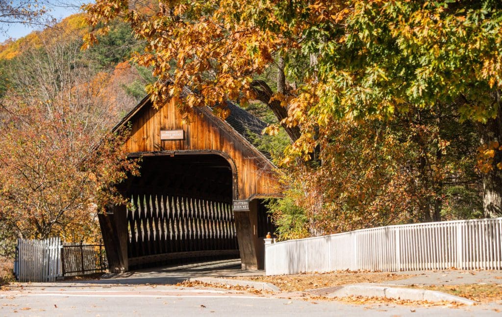 A covered bridge in Woodstock, Vermont, surrounded by vibrant fall foliage.