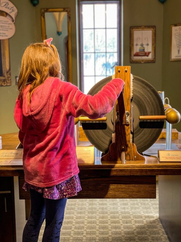 A young girl explores a hands-on exhibit on electricity at the Bakken Museum.