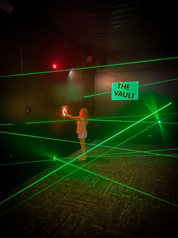 A young girl navigates a laser maze in Action City, one of the best things to do in Eau Claire with kids.