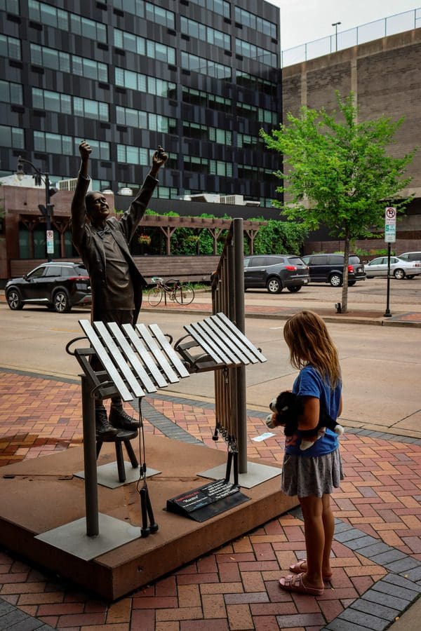 A young girl interacts with a music sculpture in downtown Eau Claire.