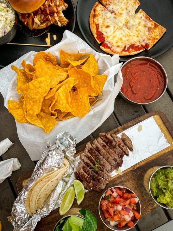 A table filled with food at 44 North, in Eau Claire, including chips, fajitas, pizza, and more.