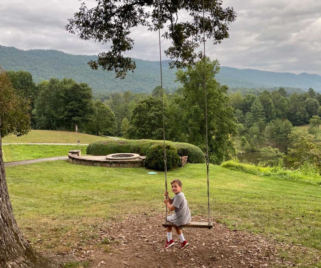 A young boy swings on a tree swing, during a family getaway to Blackberry Farm in Tennessee.