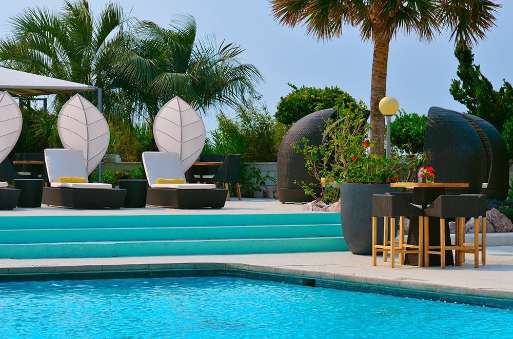 Several cabanas flank the outdoor pool at Blockade Runner Beach Resort, one of the best eco-friendly hotels in the United States for families.