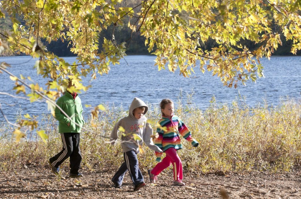 Three kids meander a hiking path along the river during the spring at Interstate State Park.