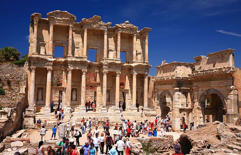 A crowd of people explore the Library of Celsus in the ancient city of Ephesus.