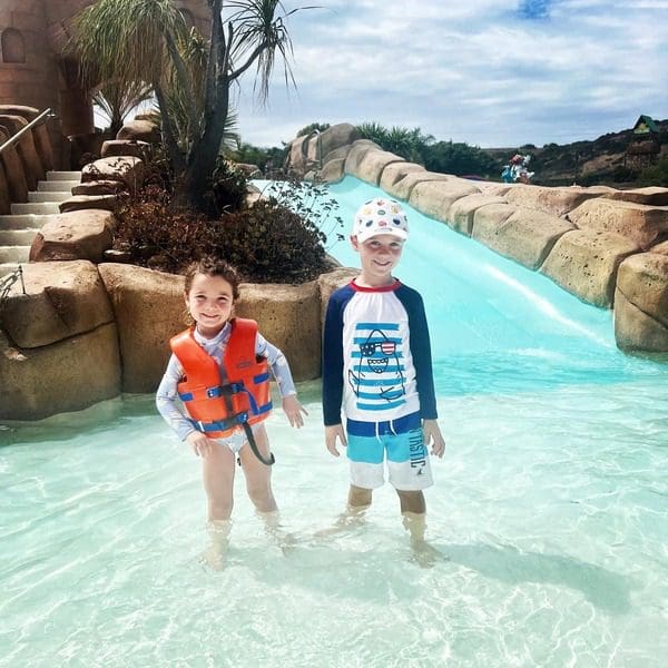 Two kids stand together in the water at Sesame Place San Diego.