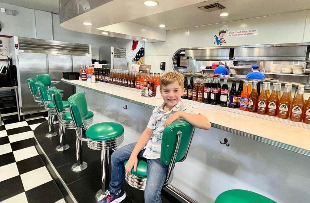 A young boy sits at a lunch counter, while exploring Temecula with his family.