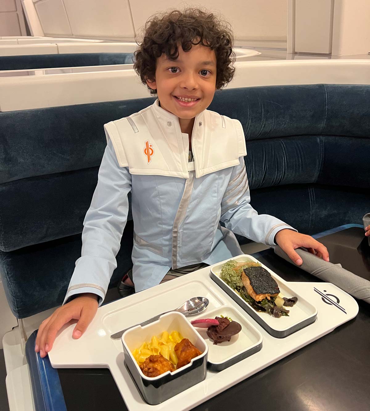 A young boy, in costume, enjoys a Star Wars themed dinner.