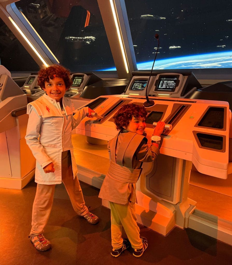 Two boys in costume pretend play at the "command center" of Star Wars Galactic Star Cruiser.
