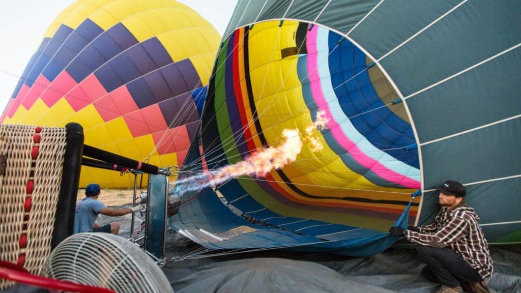 A man fills a hot air balloon in preparation of take off.