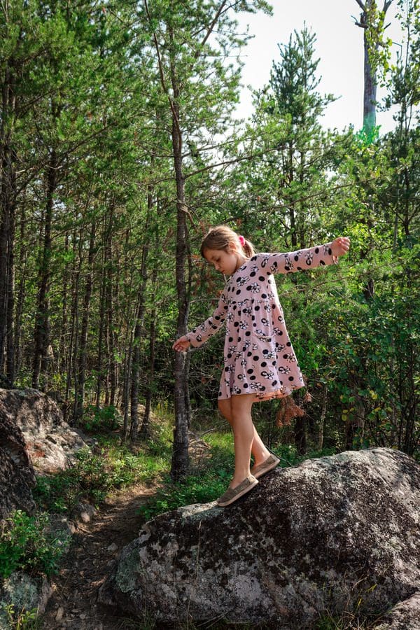 A young girl climbs on the rocks, while hiking at Chik-Wauk Museum and Nature Center.