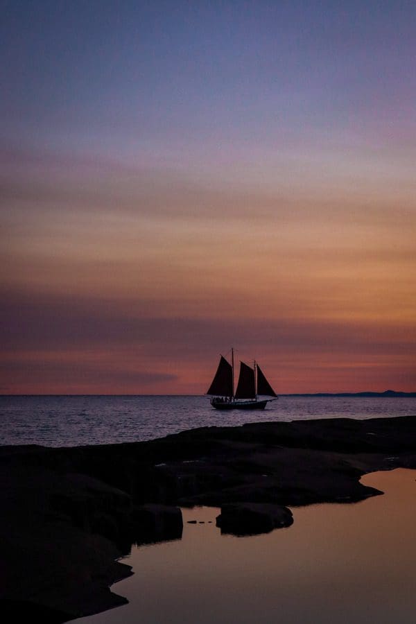 A schooner moves through the water at sunset on Lake Superior near Grand Marais.