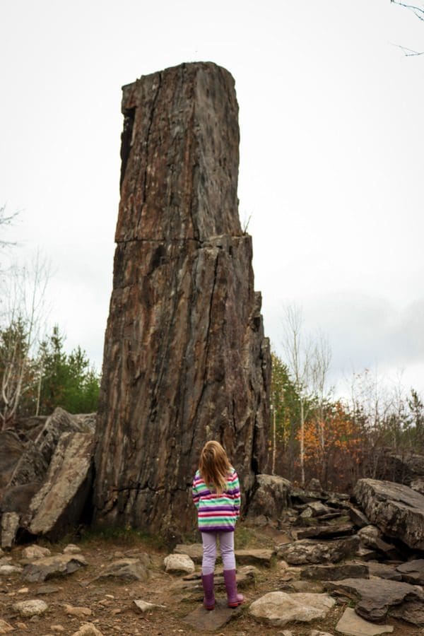 A young girl looks up a huge monolithic rock at the end of Magnetic Rock Trail in northern Minnesota.