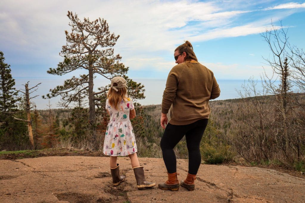 A mom and her young daughter stand along one of the vistas overlooking Lake Superior on the Oberg Mountain trail, one of the best places to visit in northern Minnesota with kids.