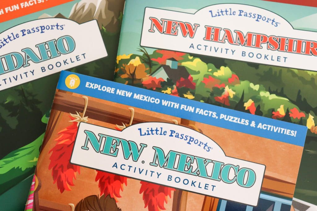 A close up of three Little Passports books featuring Idaho, New Mexico, and New Hampshire.