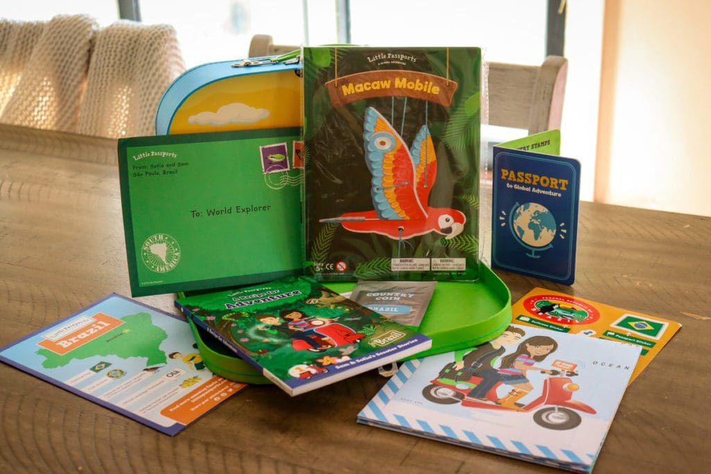 Activities from a Little Passports box, including a map, book, and macaw activity. 