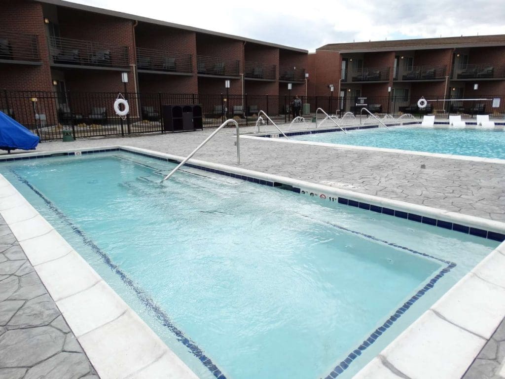 The outdoor twin pools behind the hotel building of Best Western Premier Denver East.