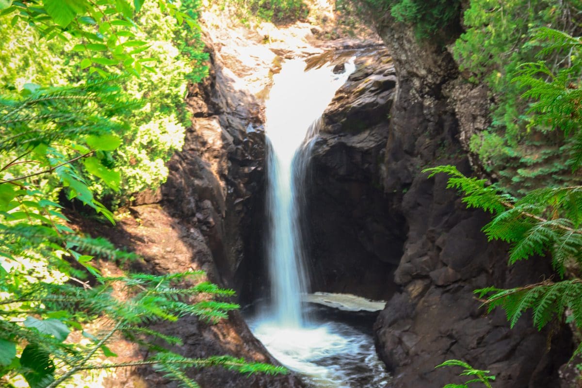 The lovely waterfall in Cascade River State Park, surrounded by lush greenery in the summer months.