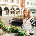 A young girl looks at a wreath covered in Easter eggs, while traveling in Europe over Easter break with her family.
