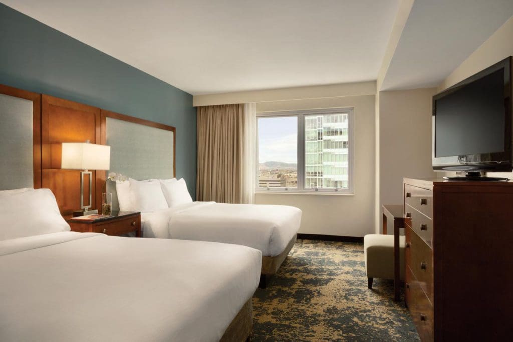 Inside one of the standard room at Embassy Suites by Hilton Denver Downtown Convention Center, featuring two queen beds.