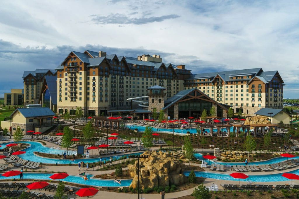 The rear exterior of Gaylord Rockies Resort & Convention Center, featuring a large outdoor network of pools and waterslides.