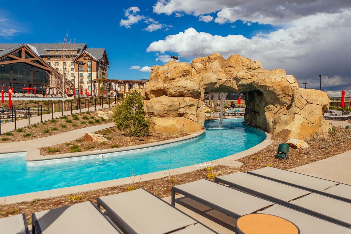 A large lazy river extends through a stone arch at Gaylord Rockies Resort & Convention Center.