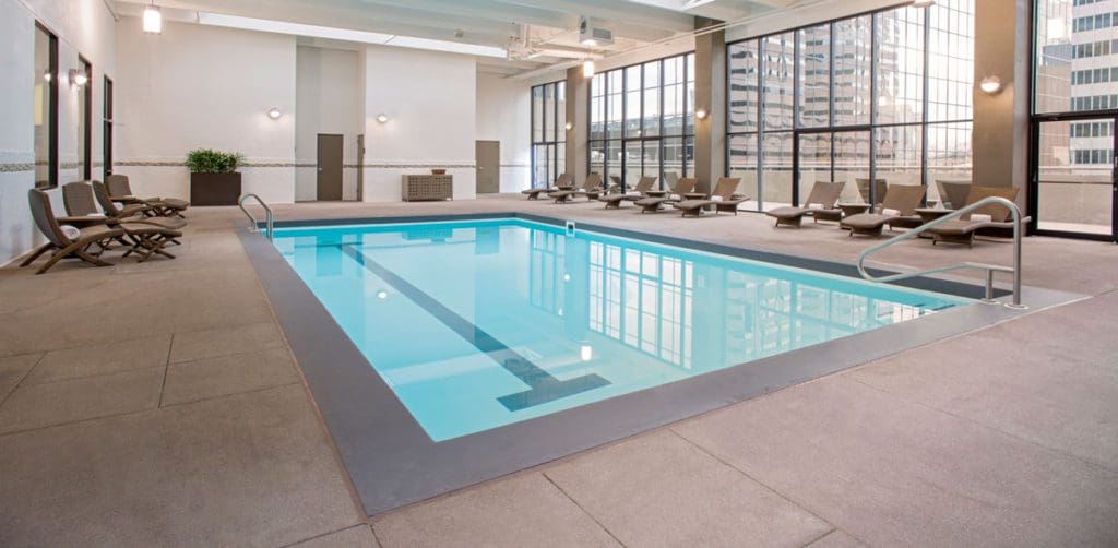 The indoor pool and surrounding pool deck, with large windows facing downtown Denver at Grand Hyatt Denver.