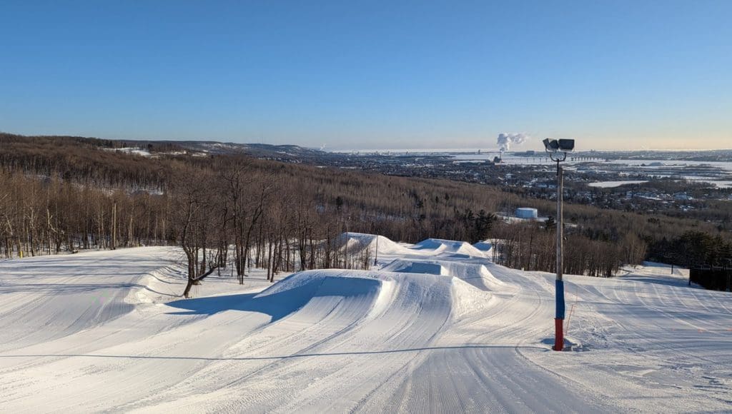 Slopes covered with snow and scenic view of Duluth from Spirit Mountain Adventure Park.