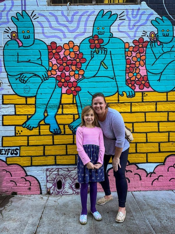 A mom and her young daughter stand in front of a mural at Freak Alley Gallery in Boise.
