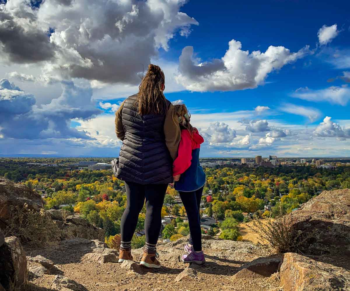 A mom and her daughter enjoy the view of downtown Boise after hiking one of the trails at Table Rock, one of the best things to do in Boise with kids.