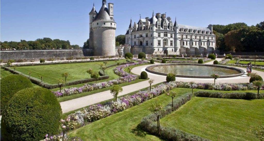 A view of the estate gardens and large building at Château de Chenonceau, one of the best museums in France with kids.
