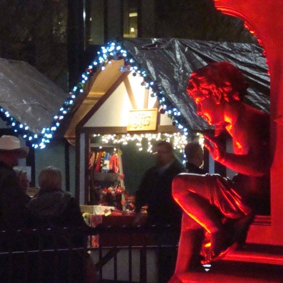 A vendor lit up at night at the Cincideutsch Christkindlmarkt, one of the best christmas markets in the United States for families.