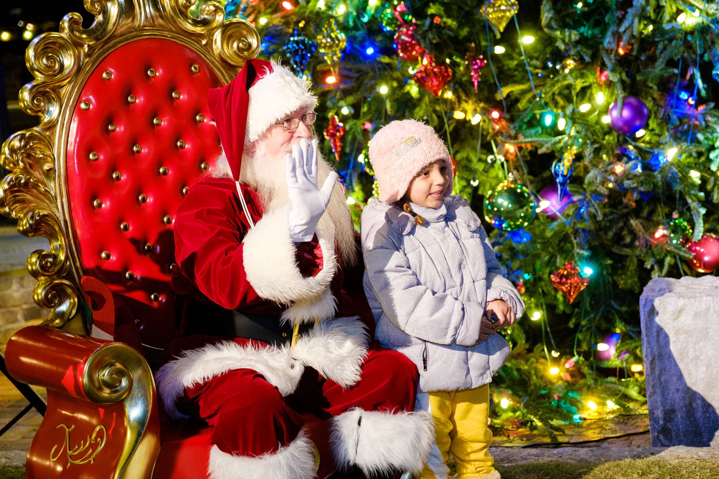 A young girl sits with Santa at the Savannah Christmas Market.