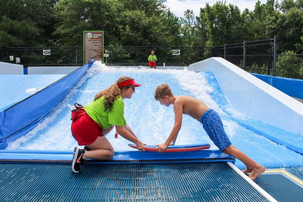 A life guard helps a young boy on a splash board at Discovery Island, a waterpark in Greenville.