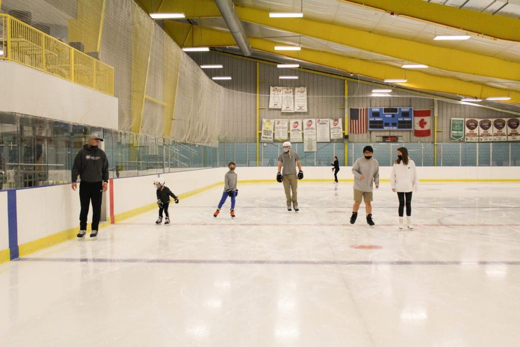 Several people enjoy open skate at a rec center in Greenville, ice skating is one of the best things to do in the area with kids.