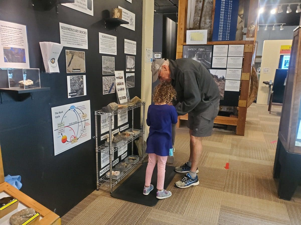A young girl and her grandpa read an exhibit together at the Idaho Museum of Mining and Geology.