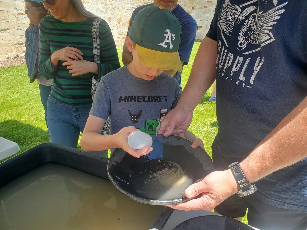 A young boy pans for gold with the help of an adult at the Idaho Museum of Mining and Geology.