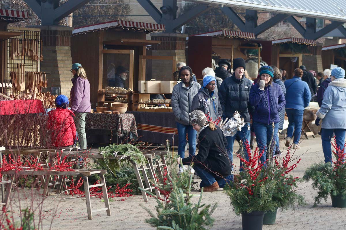 Several people enjoy the vendors and evergreens available for purchase at the Kerstmarkt Holland.