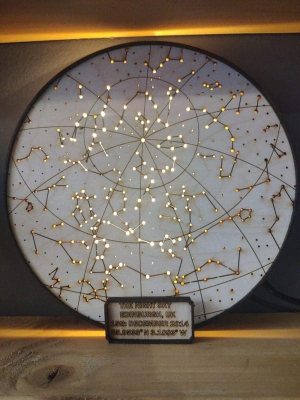 A product shot of a lit up map of the stars within a wood cut from MattWooDyouLike on Etsy.