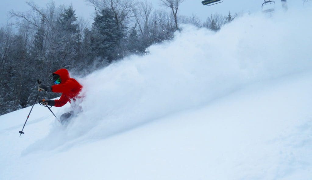 A man in red skis down an alpine slope at rapid speed at Bretton Woods Ski Resort.
